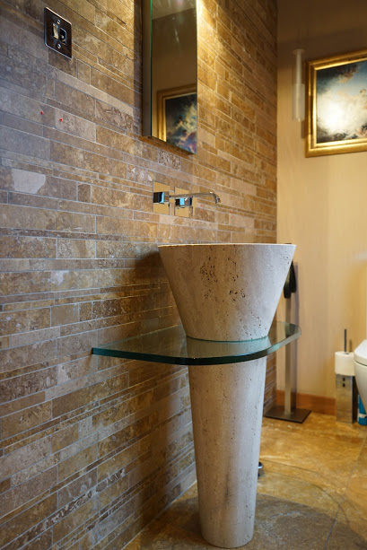 Lavabo cono freestanding e parete con rivestimenti in mosaico