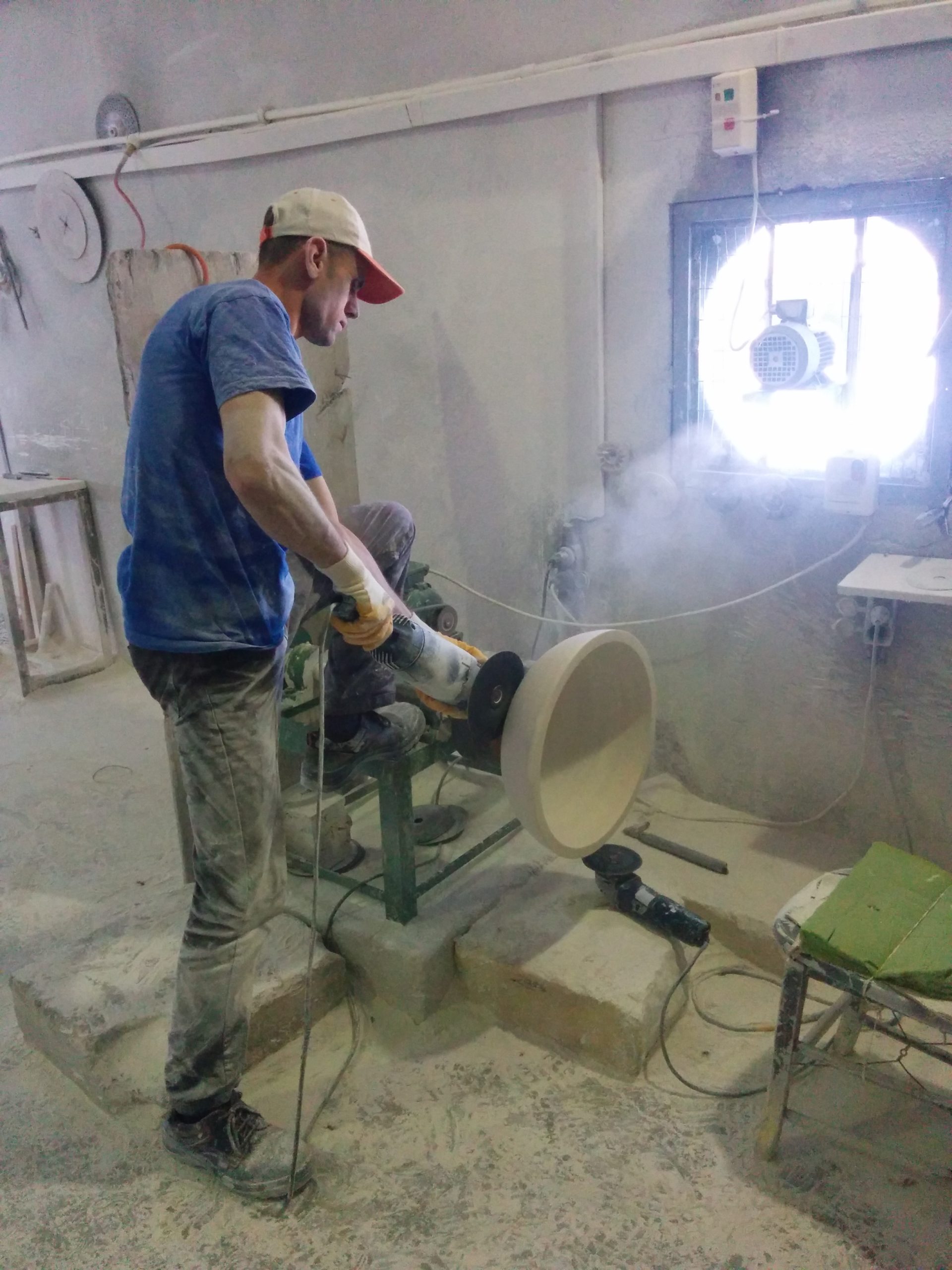 Rifinitura esterna al tornio di un lavabo in massello di Travertino