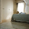 Camera da letto con pavimento in travertino chiaro