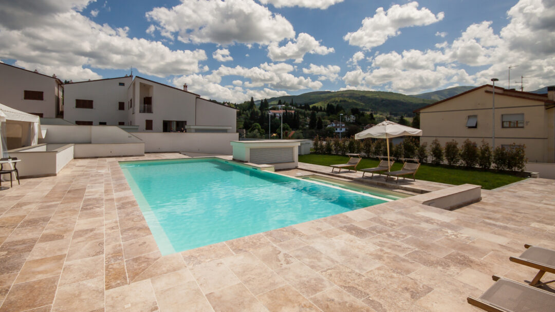 Esterno piscina in travertino Leather Brown in un resort in campagna