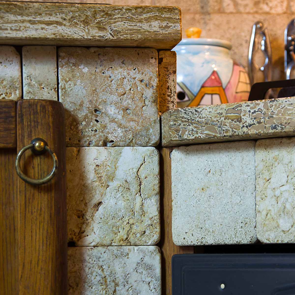 Cucina rustica in muratura rivestita in travertino e con sportelli in legno lavorato a mano Cucina rustica in muratura rivestita in travertino e con sportelli in legno lavorato a mano